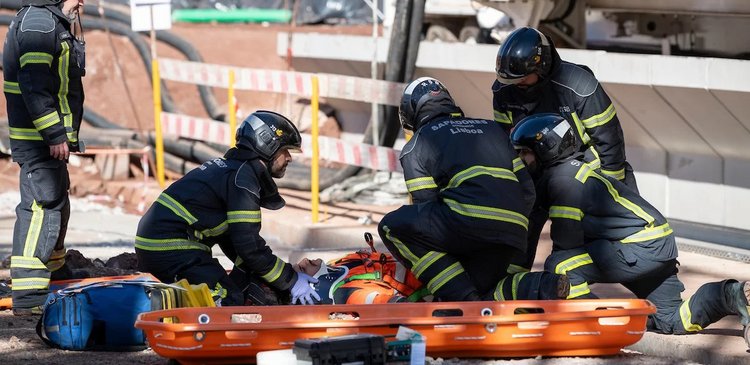 firefighters are treating a patient on the ground